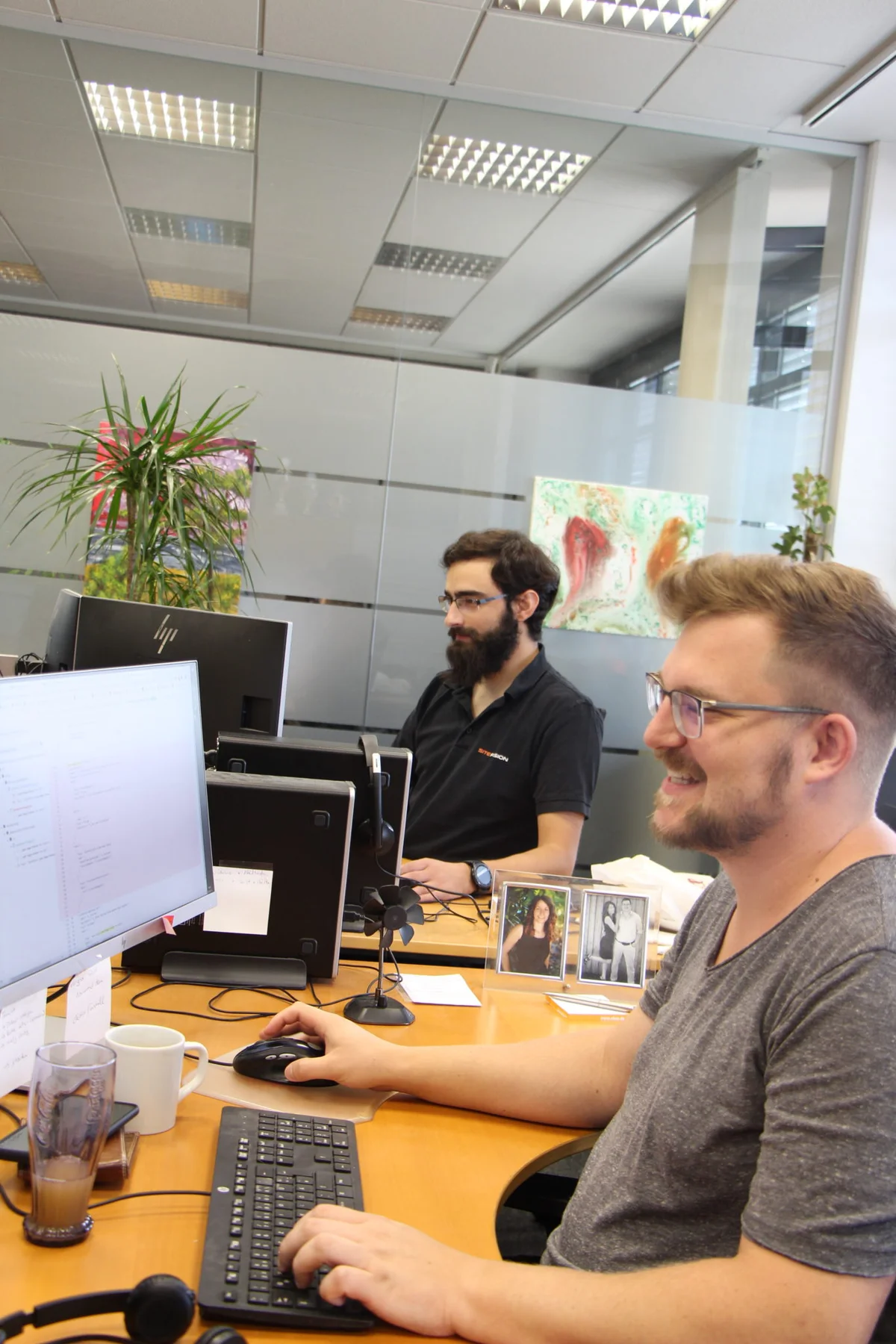 Kollegen an ihren Arbeitsplätzen im SiteFusion-Büro